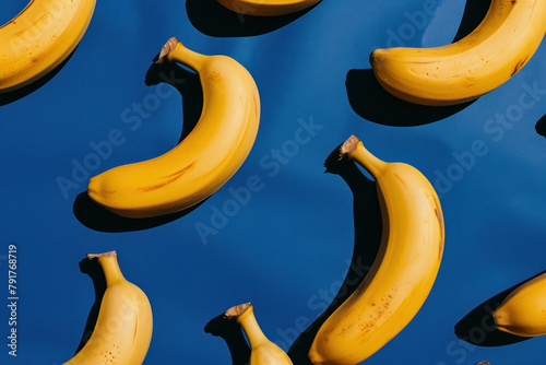 Pattern of ripe bananas on blue surface with alternating sides facing up and down