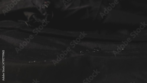 Water dripping onto waterproof fabric. Water jet on water resistant jacket. drops of water on water-repellent clothing