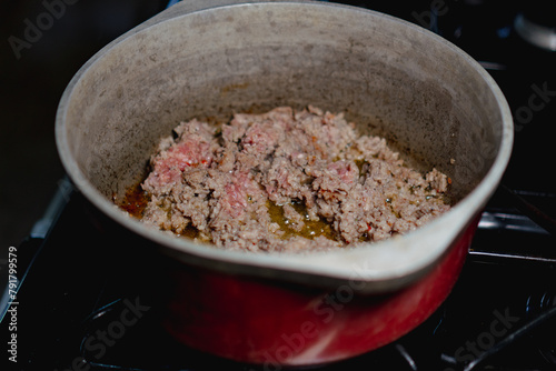 Breakfast sausage cooking in red pot on the stove  © Cam