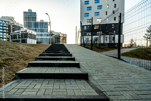 A stone sidewalk among modern buildings in the city. Urban architecture.