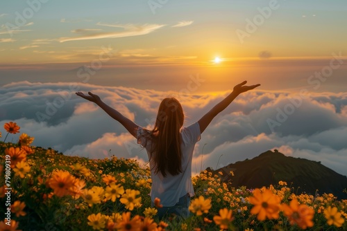 Glorious view of woman enjoying sunset over sea of clouds amid vibrant orange flowers, prompting feelings of freedom and rejuvenation, ideal for spring and summer vibes.