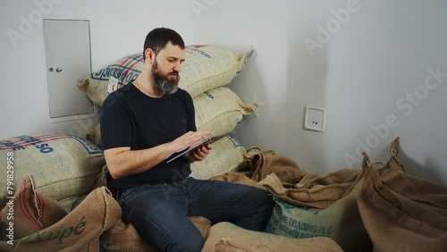 Wallpaper Mural Man in a warehouse with bags of coffee keeps records with a tablet. Torontodigital.ca