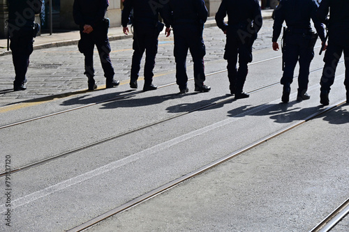 policemen lined up marching during a protest against government choices about social issues