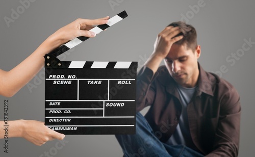 Actor performing on background of film clapperboard