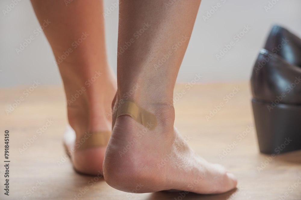 Close-up of woman's legs with adhesive bandage on heels Close-up of woman's legs with adhesive bandage on heels