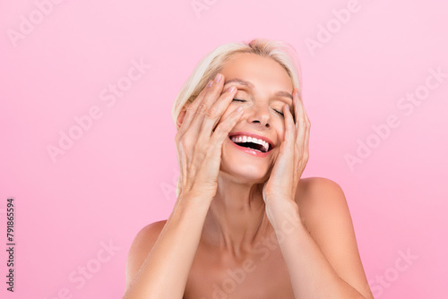 Photo of lovely dreamy retired lady naked shoulders washing face exfoliation peeling effect young skin isolated on pink color background