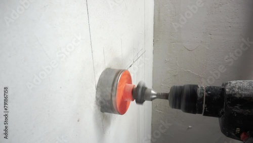 Drilling the wall to install the outlet.