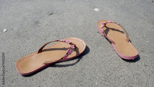 View of a pair of sandals on a sandy beach