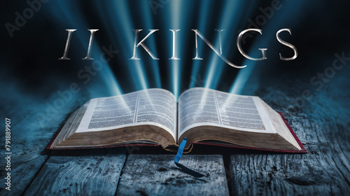 The book of II Kings. Open bible with blue glowing rays of light. On a wood surface and dark background. Related to this book: Monarchy, Prophets, Rebellion, Exile, Miracles, Judah, Israel, Kings photo