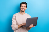 Photo of young nice man use wireless laptop coworking wear beige sweatshirt isolated on blue color background
