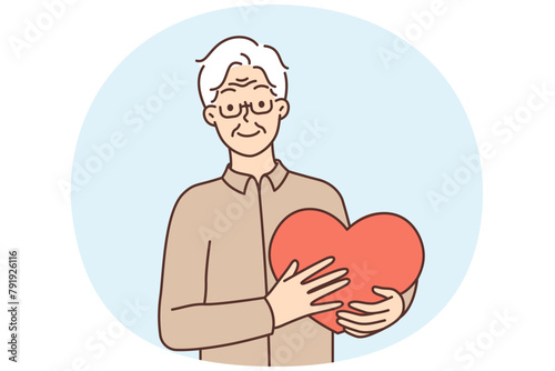 Smiling mature man hold big heart in hands
