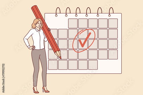 Woman is engaged in business planning and uses calendar to keep schedule, standing with large pencil in hand. Businesswoman making planning to increase productivity and avoid missing deadlines