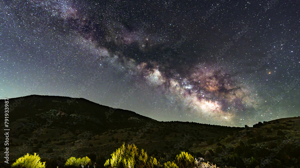 Milky Way core over a mountain forest in silhouette