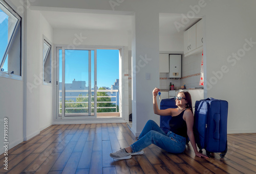 Photos Mujer sentada en el suelo de apartamento vacío, con llaves y maletas, concepto i