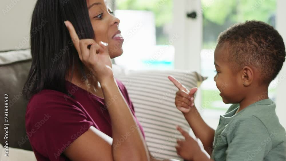A mother practices counting with her young son at home A mother practices counting with her young son at home
