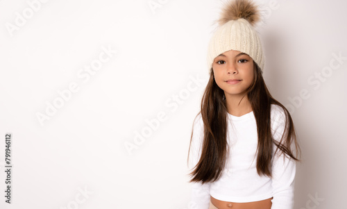 Closeup of pretty cute little girl wearing winger hat with long hair over white background photo