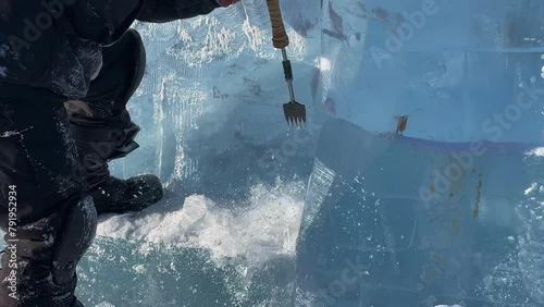 slow motion. a man makes a product out of ice. A man cleans the ice. a man chops off a piece of ice.The guy is making something out of ice. a trip to Lake Baikal photo
