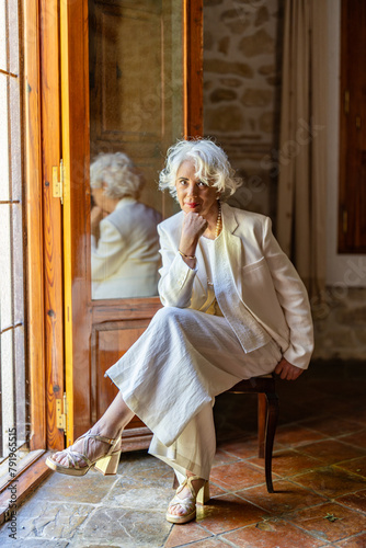 Portrait of a white-haired woman in her sixties dressed elegantly in fashion