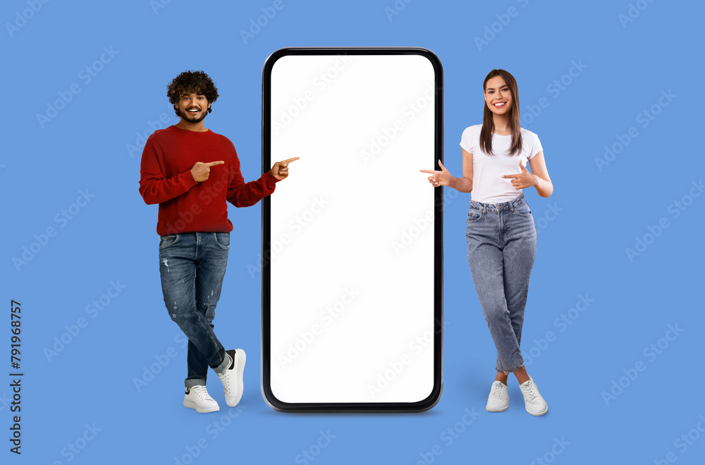 Obraz premium Casual Multiracial couple with oversized smartphone mockup