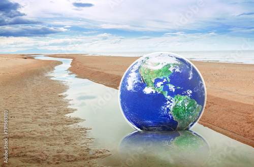 Hope to save the Earth concept, Globe earth on sand by the sea on a bright day, Elements of this image furnished by NASA