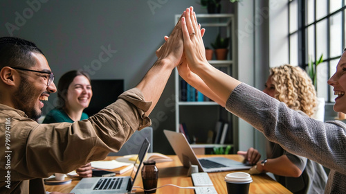 Colleagues Celebrating Success With A High Five In A Modern Office Environment. photo