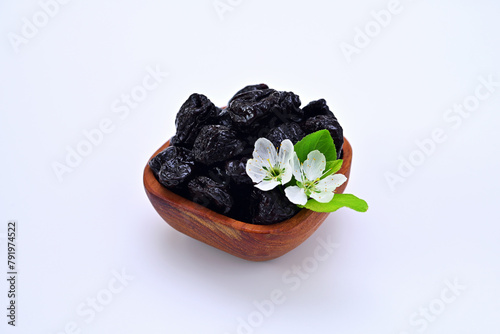 bowl with prunes and plum flowers on a white background