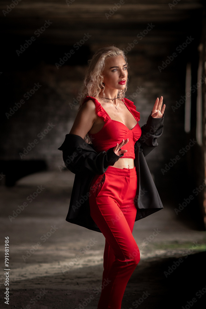 Portrait of a beautiful blonde girl in red clothes in a low key. Portrait of a beautiful blonde girl in red clothes in a low key.