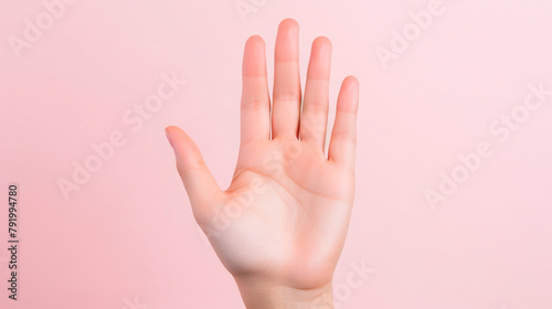female hand shows stop sign on pink background, stop stop