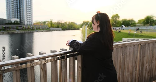 young happy smiling business woman is making a conference video call conference or distances meeting in city park in front of the riiver, lake a modern urban background, outside, outdoors. photo