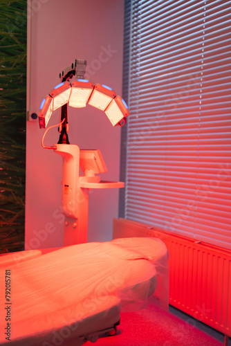 Phototherapy device with red light wavelength for acne treatments and collagen production. Interior of modern aesthetic room with special equipment LED light therapy for skin rejuvenation. photo