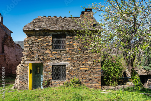 Small stone houses with green meadows and flowers on the north mountain of Guadalajara, Spain.