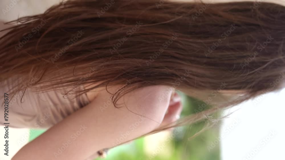 A girl with beautiful long hair stands with her back turned. The wind blows your hair. Vertical video. A girl with beautiful long hair stands with her back turned. The wind blows your hair. Vertical video.