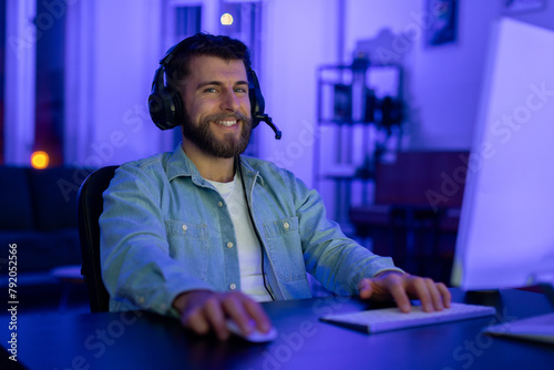 Smiling gamer with a headset and a microphone