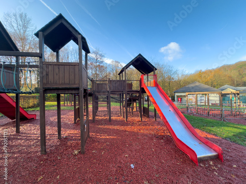 Colorful playground with climbing stairs and slides on yard in the park. 