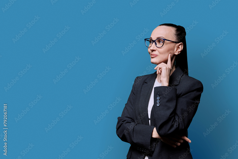 Portrait of thinking serious confident business woman , on blue studio background Portrait of thinking serious confident business woman , on blue studio background