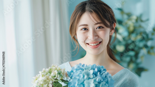 アジサイの花束を持つ若い女性