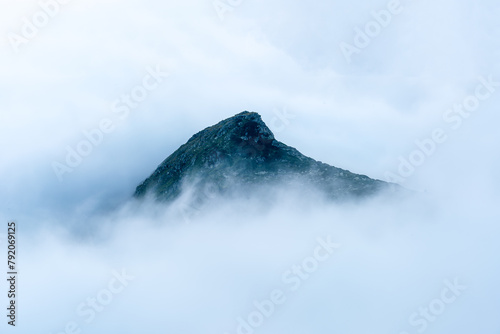 Isolated mountain peak surrounded by a sea of clouds