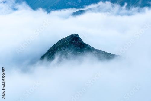 Isolated mountain peak surrounded by a sea of clouds