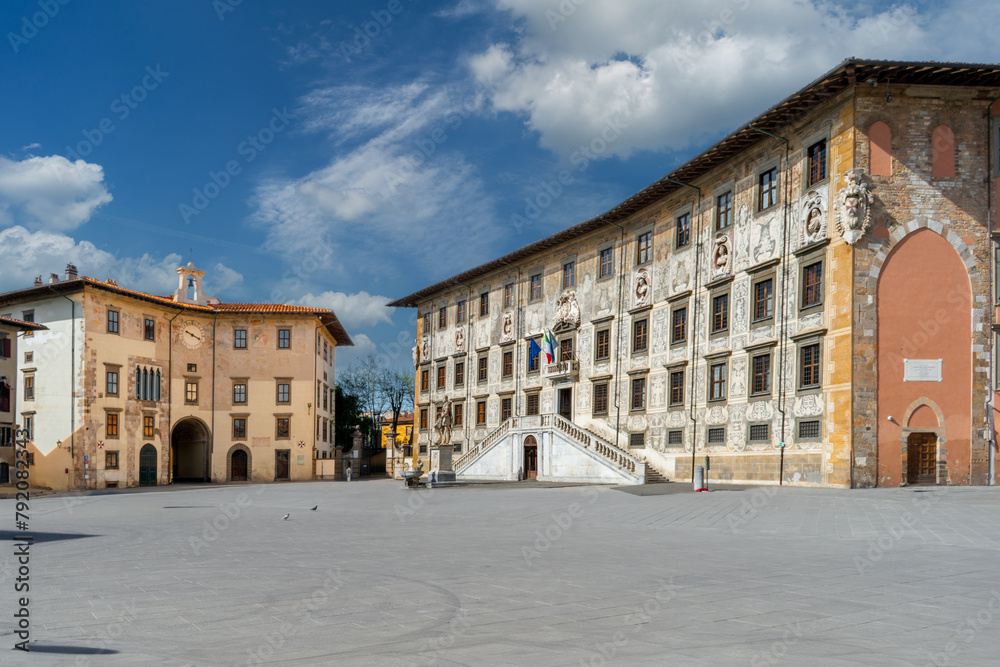 Pisa, Italy - April 05, 2024: Piazza dei Cavalieri with Palazzo della Carovana, home of the Scuola Normale Superiore and the clock building