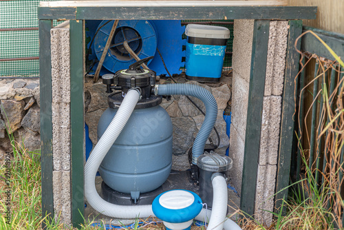Pool equipment with filtration system and pump in yard for clean swimming water. photo