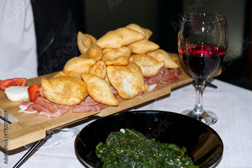 Italian appetizer. Fried bread crescentine or gnocco fritto with jambon and red wine