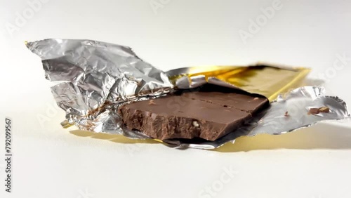 unwrapped chocolate bar with nuts, cholate bar wrapped in foil