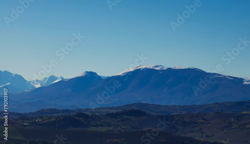 Fototapeta Naklejka Na Ścianę i Meble -  Montagne azzurre innevate e valli in una giornata di sole invernale