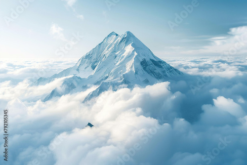 Pristine mountain peak piercing through a layer of fluffy clouds