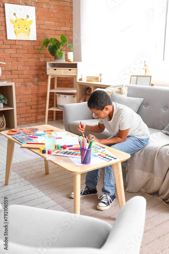 Young boy painting with wat...