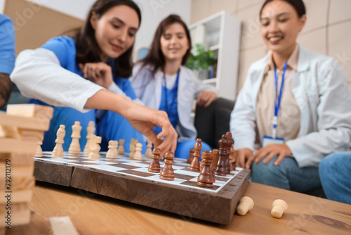 Team of doctors playing chess in hospital lounge