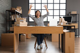 Happy Asian seller working at table in warehouse store