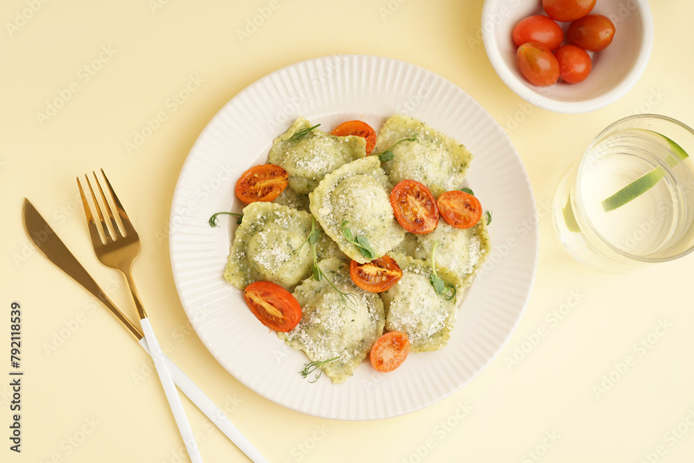 Plate of tasty ravioli and glass with water on yellow background Plate of tasty ravioli and glass with water on yellow background