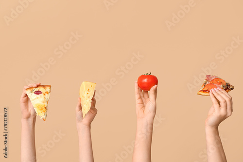 Many hands holding pizza slices, tomato and cheese on beige background