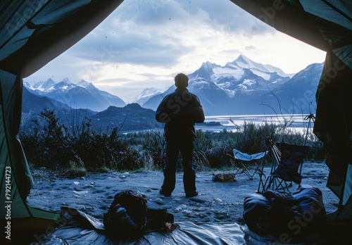 Man Standing in Front of Tent With Mountains in Background